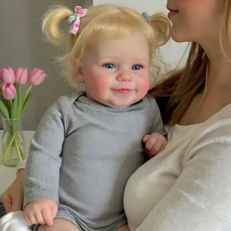 A 20-inch (50 cm) full vinyl reborn baby girl doll named Maddie with rooted blonde hair.